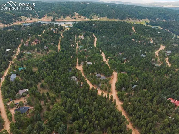 an aerial view of residential houses with outdoor space and trees