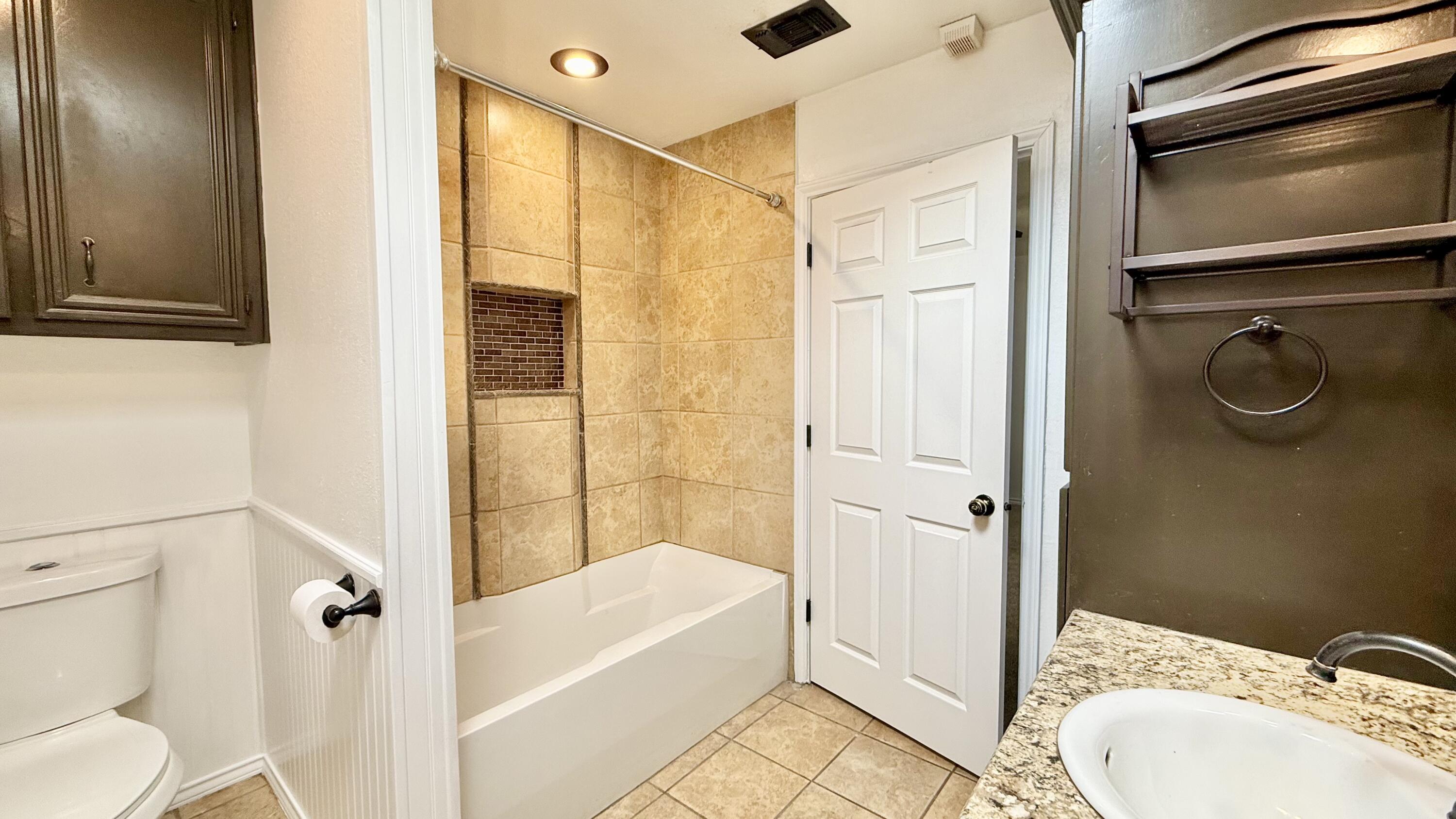 502 North Homestead Avenue Lubbock, TX 79416 - Photo 12 of 33 a bathroom with a sink a toilet and shower