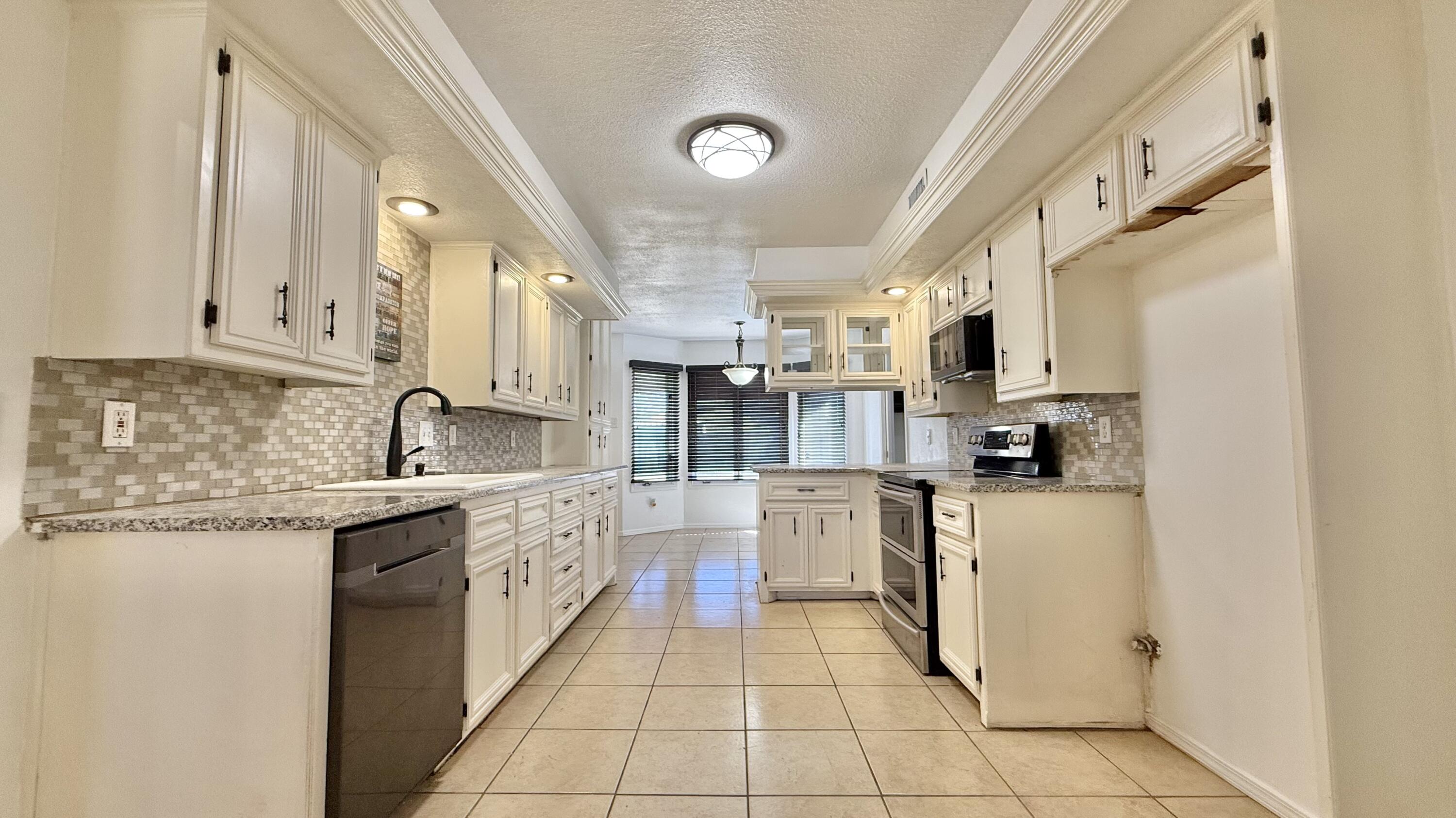502 North Homestead Avenue Lubbock, TX 79416 - Photo 7 of 33 a kitchen with stainless steel appliances granite countertop a refrigerator and a stove