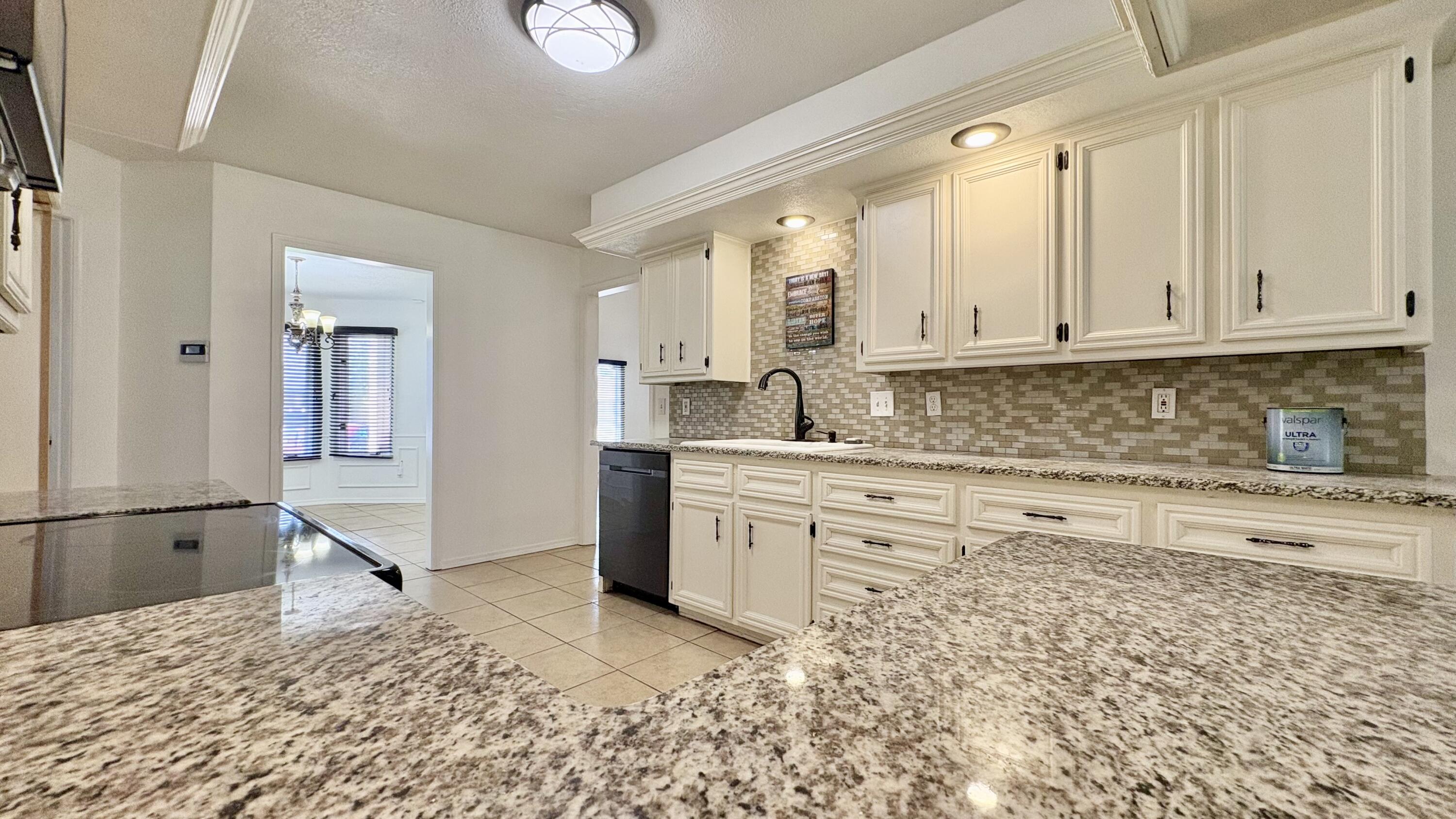 502 North Homestead Avenue Lubbock, TX 79416 - Photo 9 of 33 a kitchen with granite countertop white cabinets and white appliances