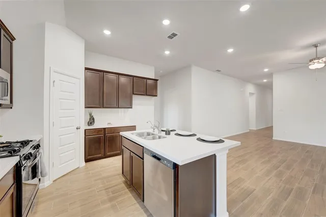 a kitchen with stainless steel appliances granite countertop a sink stove and refrigerator