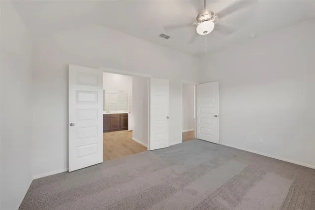 an empty room with fan and entrance