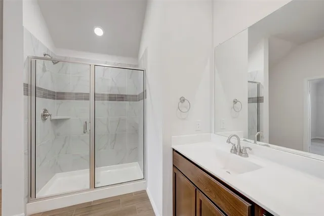 a bathroom with a shower sink and mirror