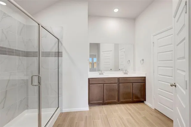 a bathroom with a double vanity sink a mirror and a bathtub