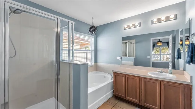 a bathroom with a tub sink and mirror