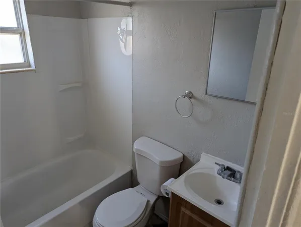 a white toilet sitting next to a bath tub
