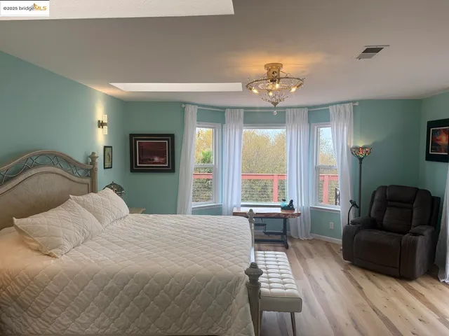 a bedroom with a bed and a large window