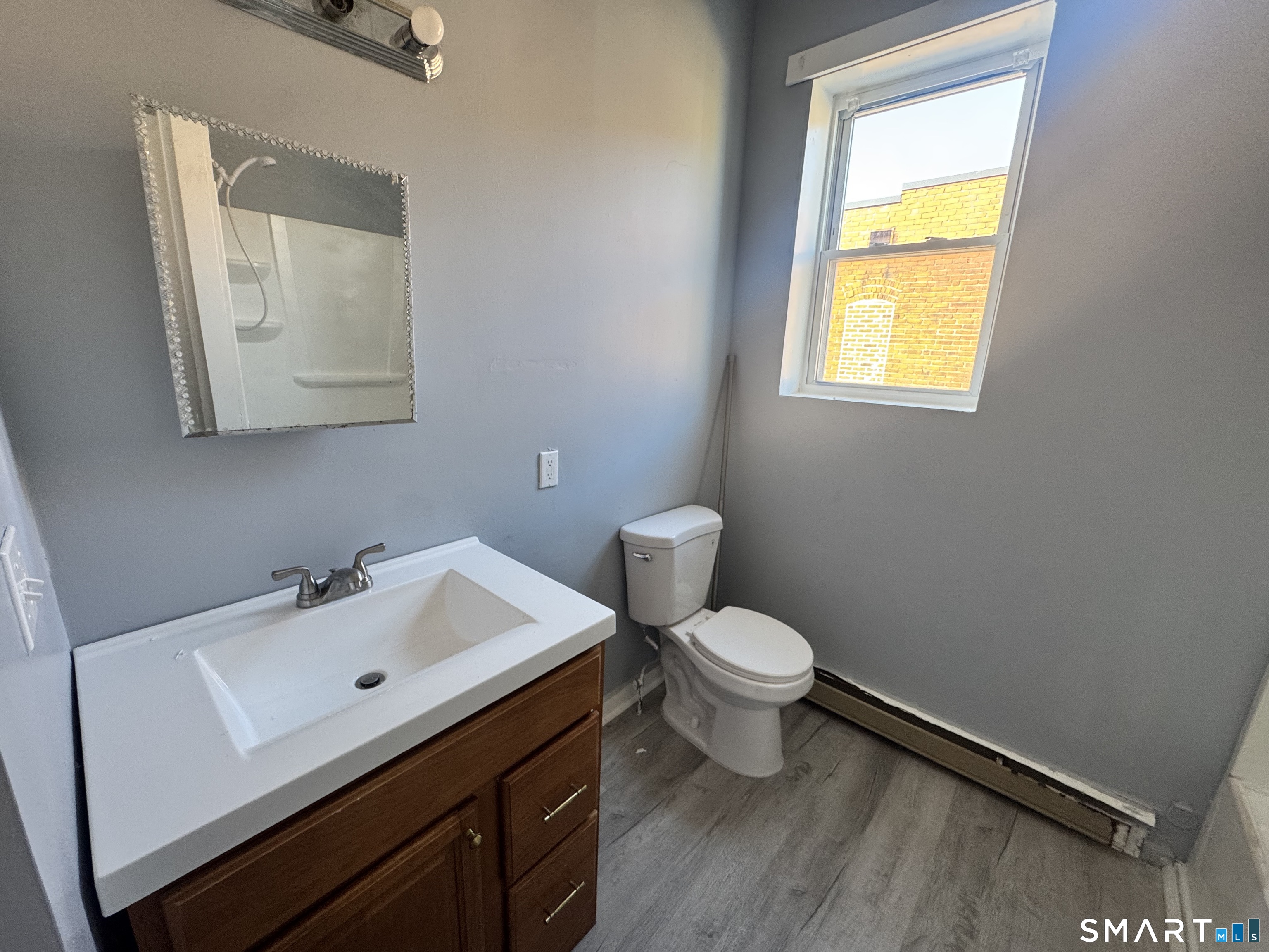283 Wethersfield Avenue, Unit C2 Hartford, CT 06114 - Photo 2 of 7 a bathroom with a toilet sink and mirror
