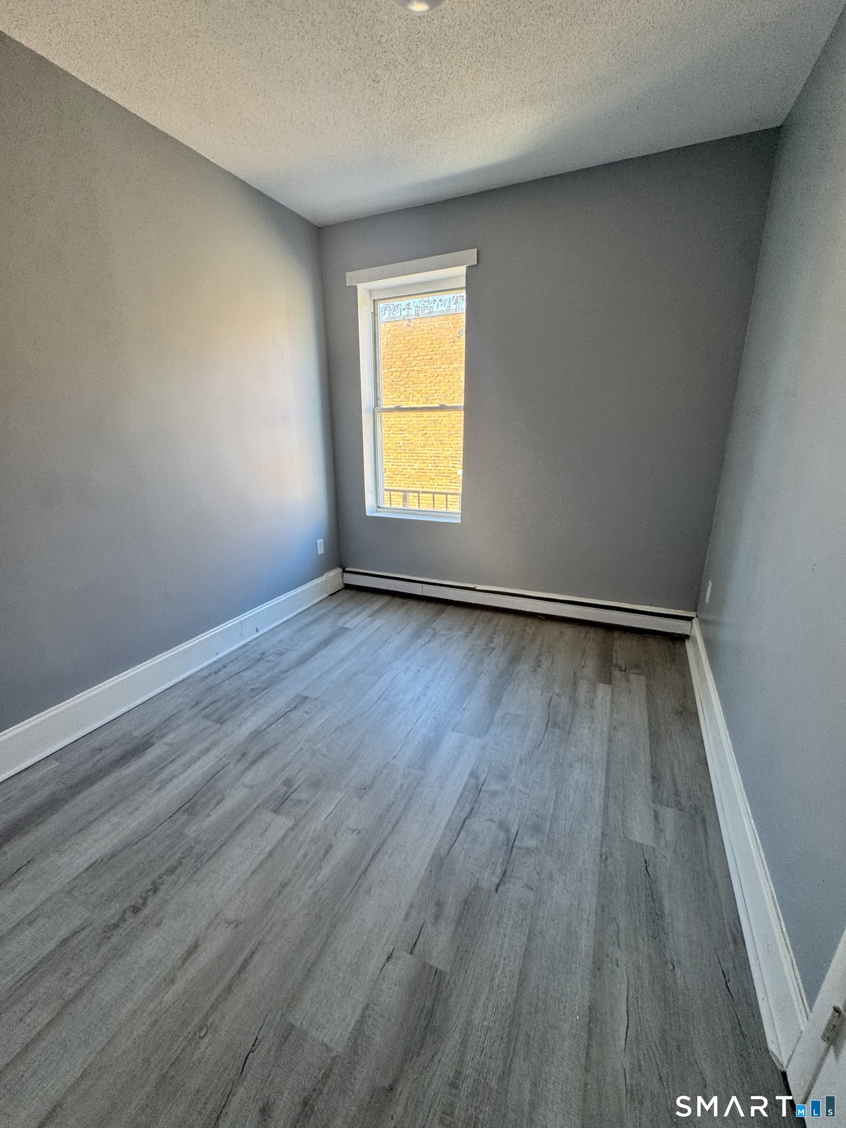 283 Wethersfield Avenue, Unit C2 Hartford, CT 06114 - Photo 4 of 7 a view of an empty room with wooden floor and a window