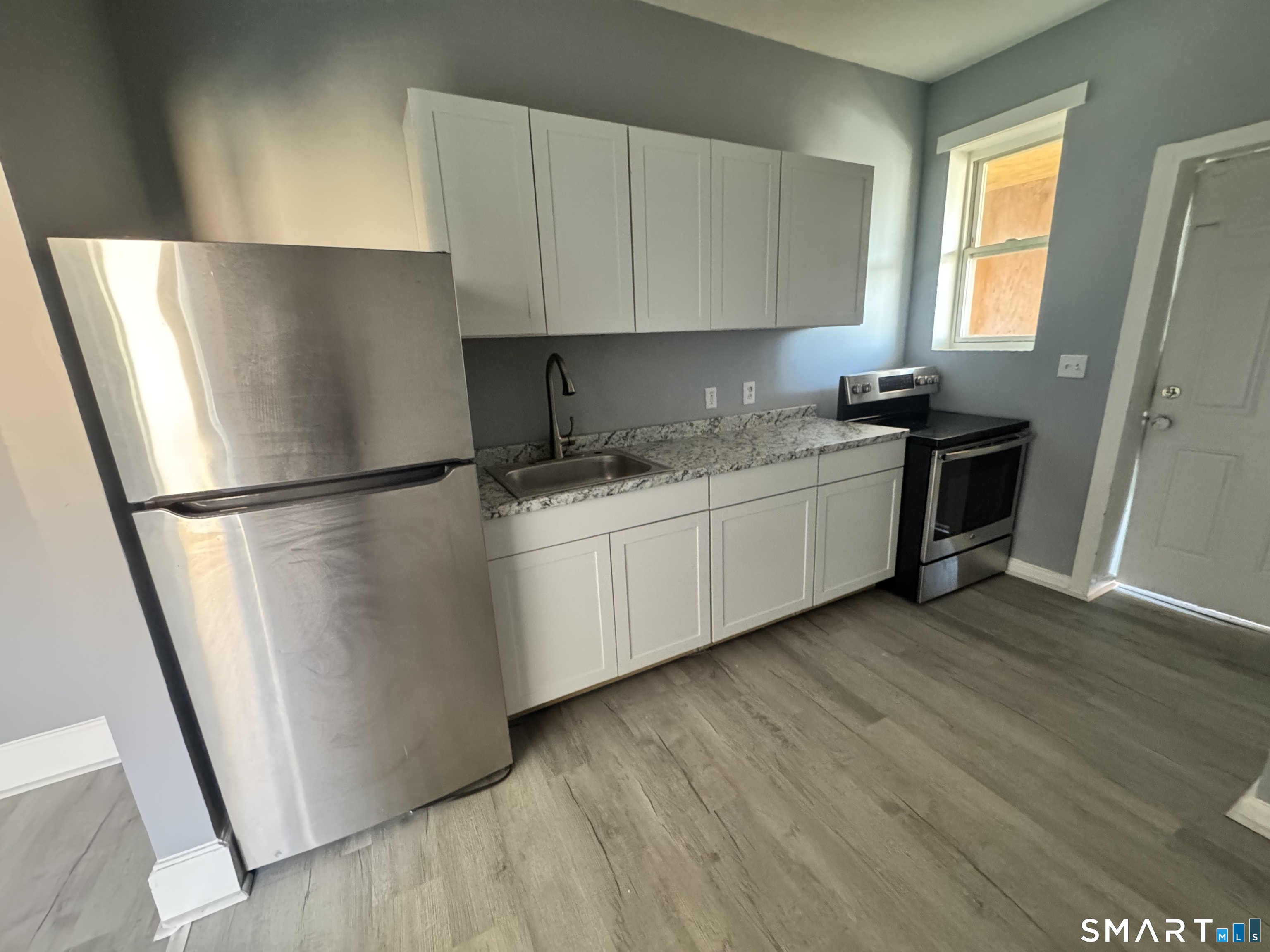 283 Wethersfield Avenue, Unit C2 Hartford, CT 06114 - Photo 5 of 7 a kitchen with stainless steel appliances a refrigerator sink and wooden floor