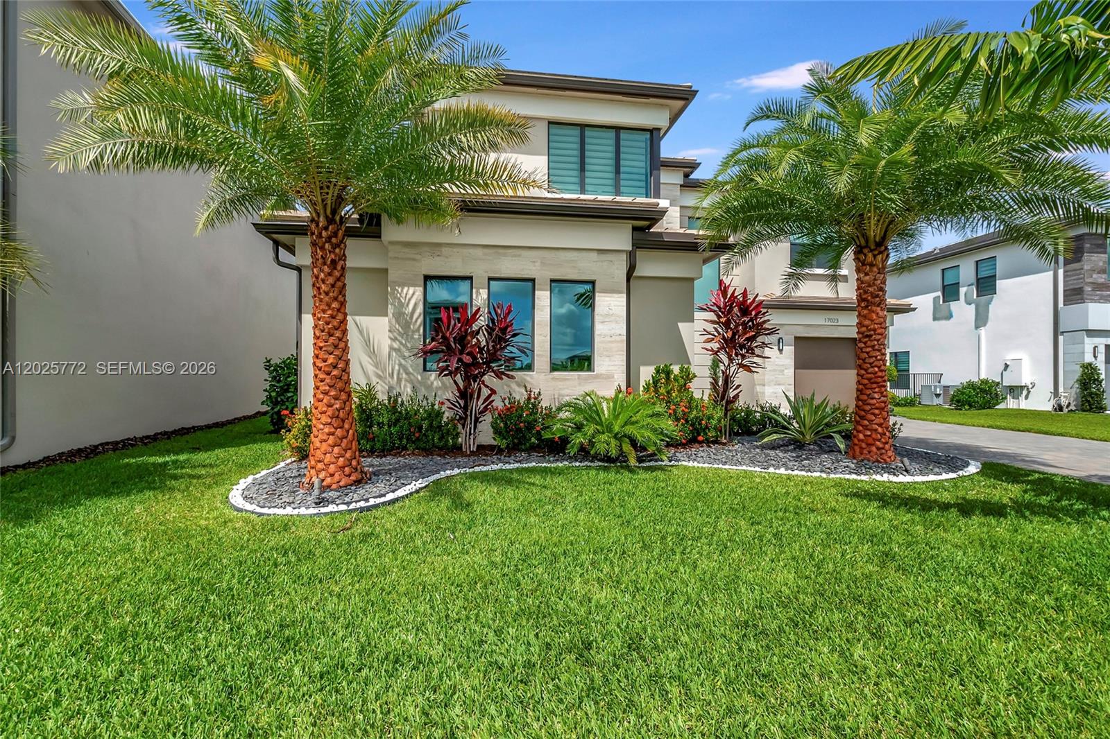17023 Wandering Wave Avenue Boca Raton, FL 33496 - Photo 8 of 84 a front view of a house with a yard