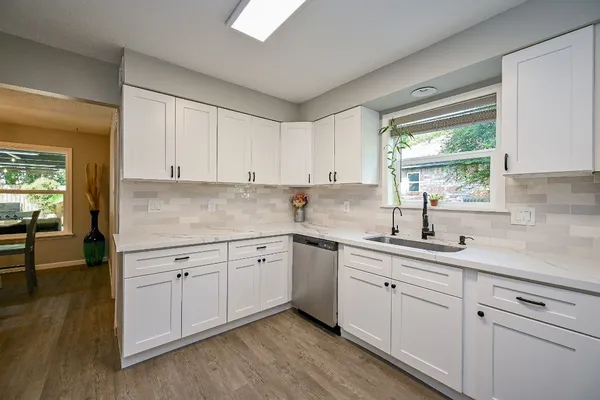a kitchen with white cabinets and a window