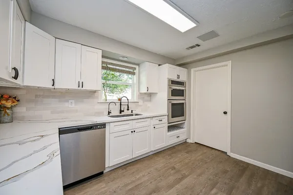 a kitchen with white cabinets and white appliances