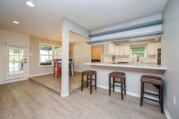 a kitchen with granite countertop a table chairs stove and wooden floor