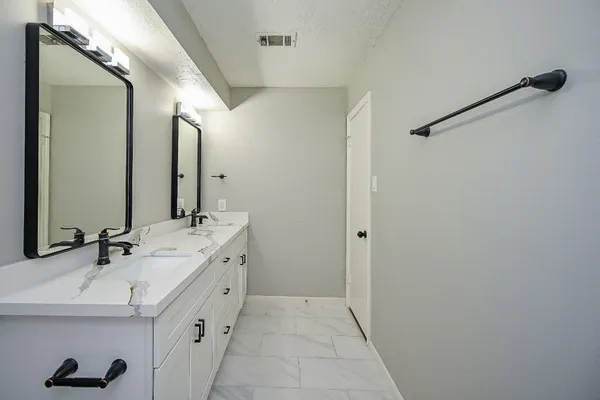 a bathroom with a double vanity sink and mirror