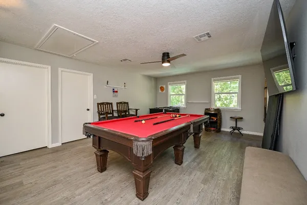 a room with pool table and windows