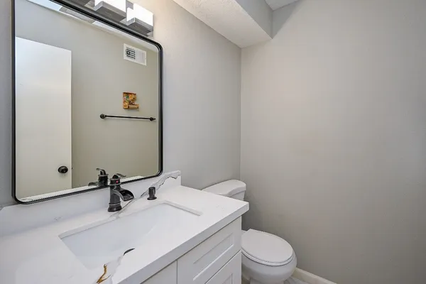 a bathroom with a sink a toilet and mirror