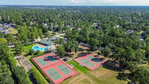 an aerial view of a house with a yard and large trees