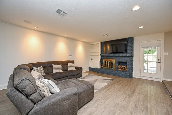 a living room with furniture a flat screen tv and a fireplace