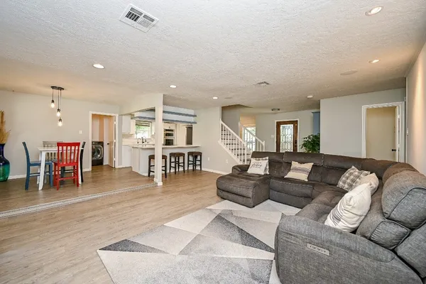 a living room with furniture and a wooden floor
