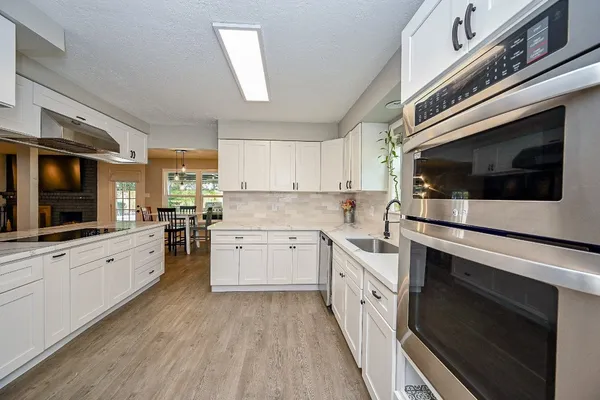 a kitchen with stainless steel appliances kitchen island granite countertop white cabinets and white appliances