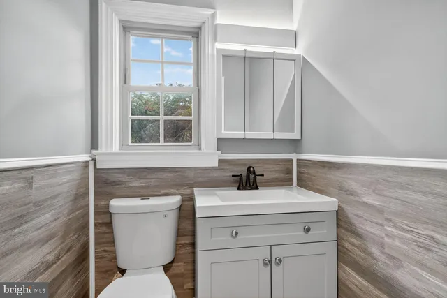 a bathroom with a toilet sink and mirror