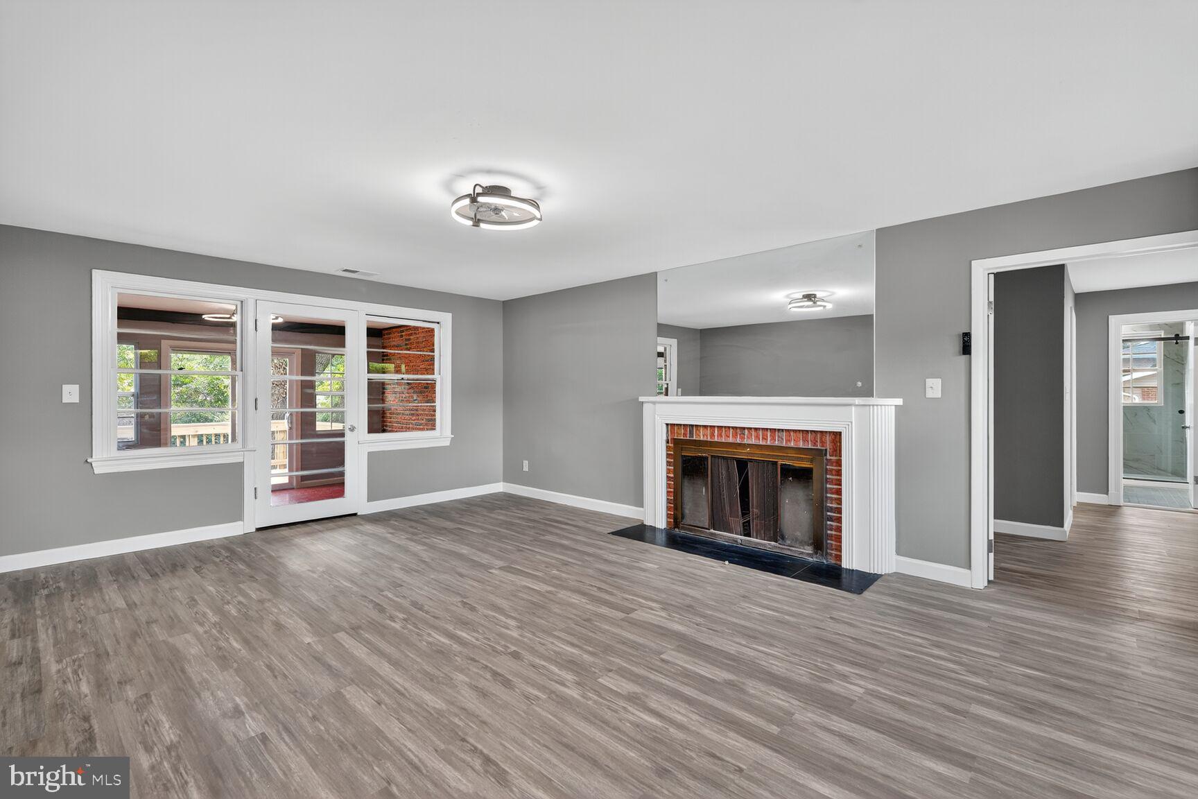 3612 Swann Road Suitland, MD 20746 - Photo 2 of 30 an empty room with wooden floor fireplace and windows