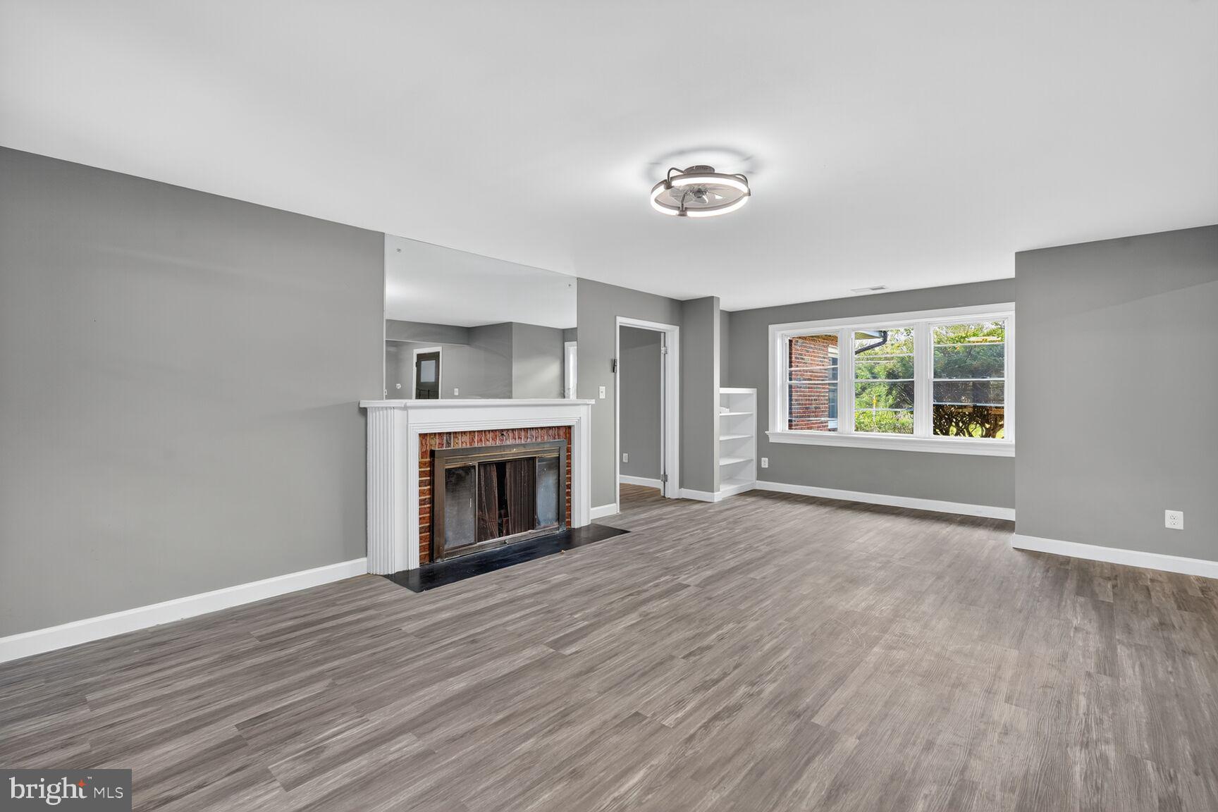 3612 Swann Road Suitland, MD 20746 - Photo 4 of 30 an empty room with wooden floor fireplace and windows