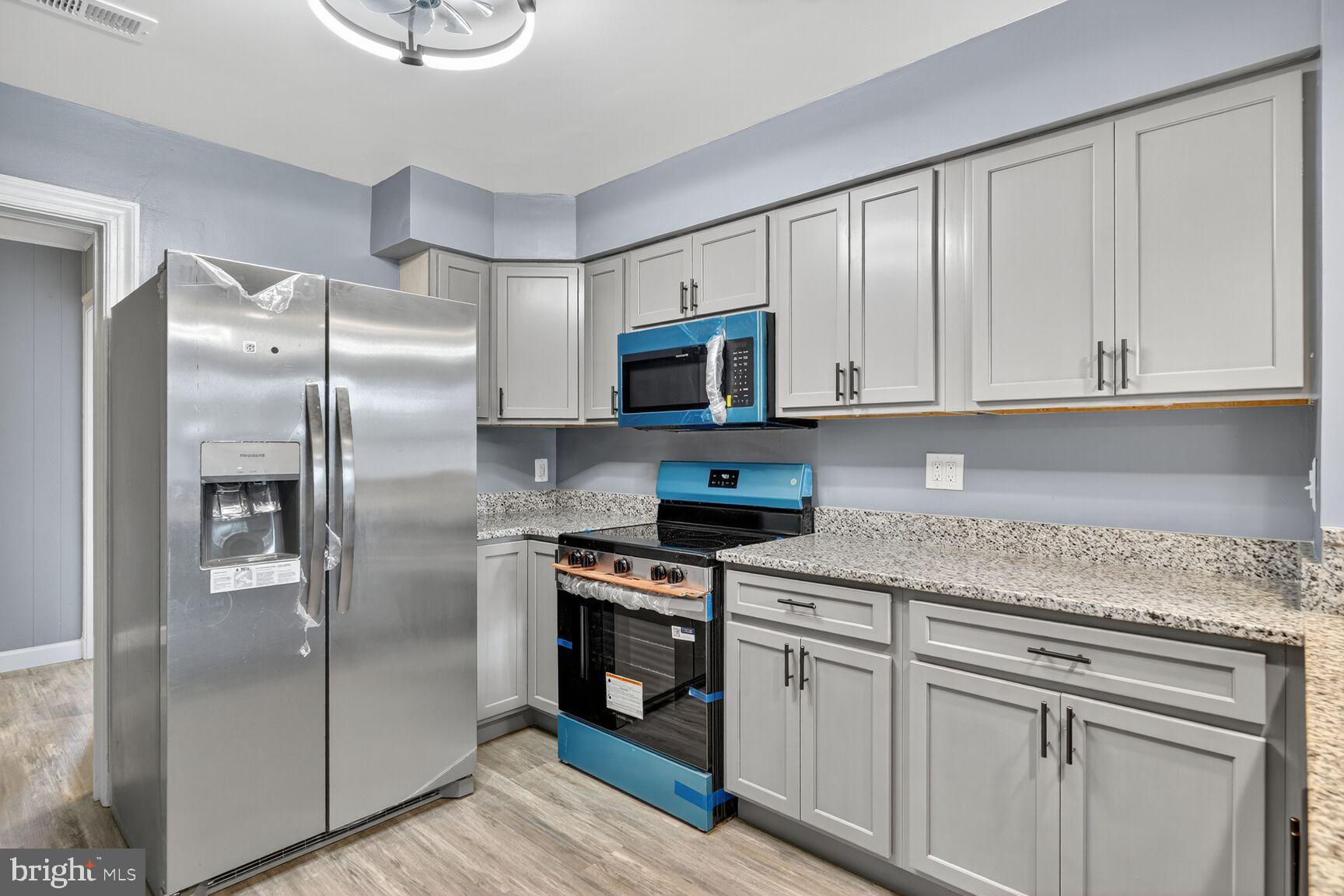 3612 Swann Road Suitland, MD 20746 - Photo 9 of 30 a kitchen with stainless steel appliances granite countertop a refrigerator a stove a sink and white cabinets