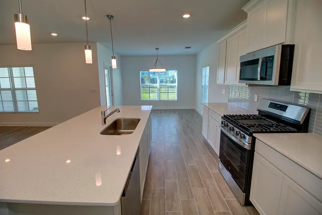a kitchen with granite countertop a stove and a wooden floor