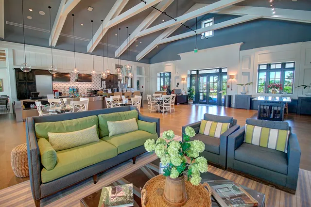 a living room with furniture kitchen view and a chandelier