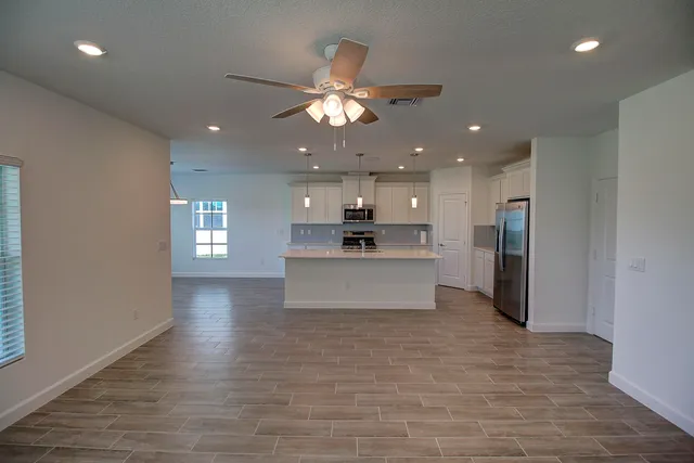 a large kitchen with kitchen island a stove a refrigerator a sink and a fireplace