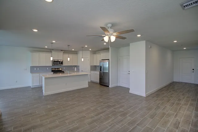 a view of kitchen with granite countertop cabinets and refrigerator