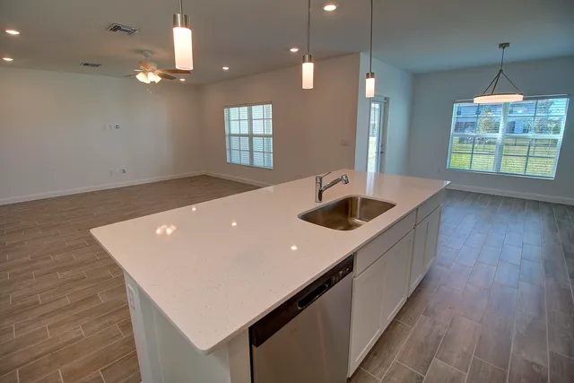 a kitchen with kitchen island a sink appliances and living room