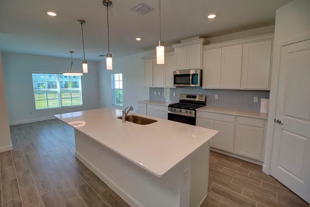 a kitchen with a sink a stove a refrigerator and a center island
