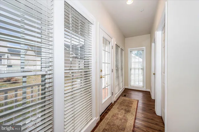 a view of a hallway with wooden floor and a window
