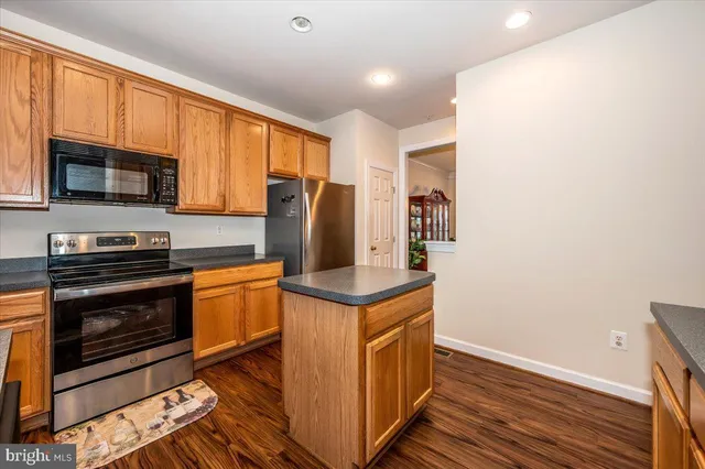 a kitchen with stainless steel appliances granite countertop a stove a refrigerator and a microwave