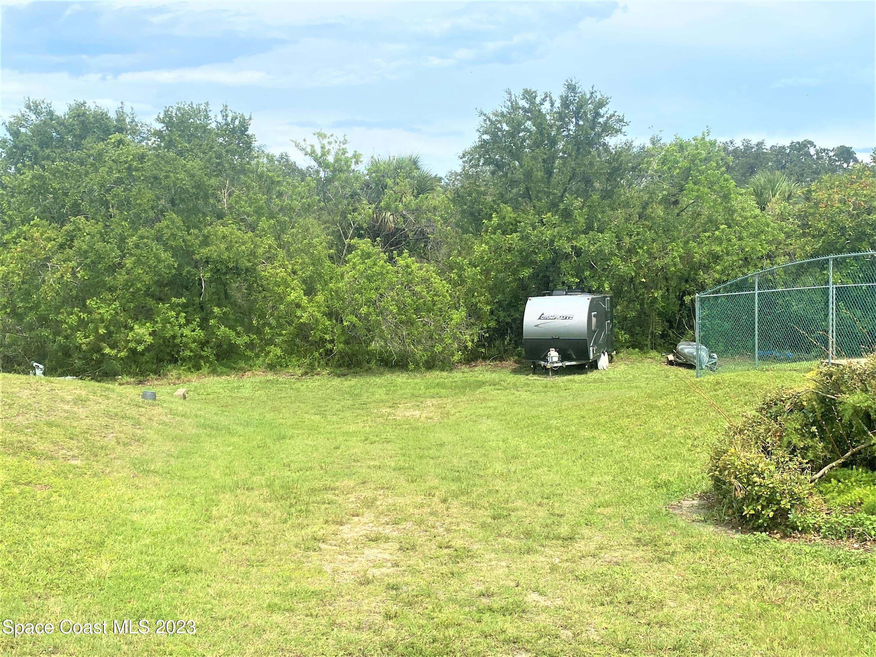1850 Quail Trail Melbourne, FL 32935 - Photo 22 of 23 a backyard of a house with lots of green space and fountain