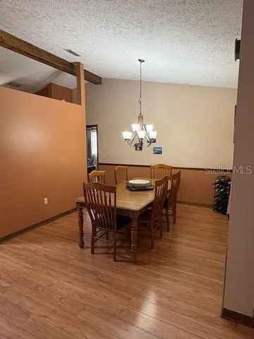 a kitchen with stainless steel appliances granite countertop a refrigerator a sink dishwasher a stove and white countertops with wooden floor