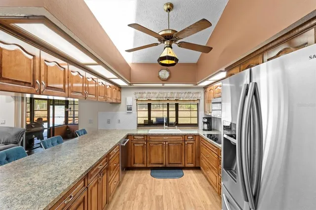 a kitchen with stainless steel appliances kitchen island a table and chairs in it