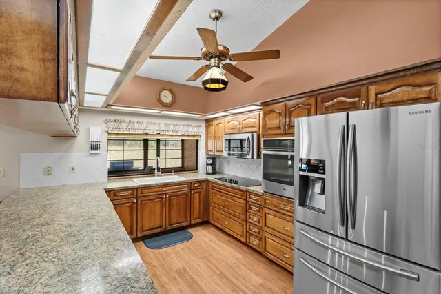 a living room with furniture ceiling fan and a wooden floor
