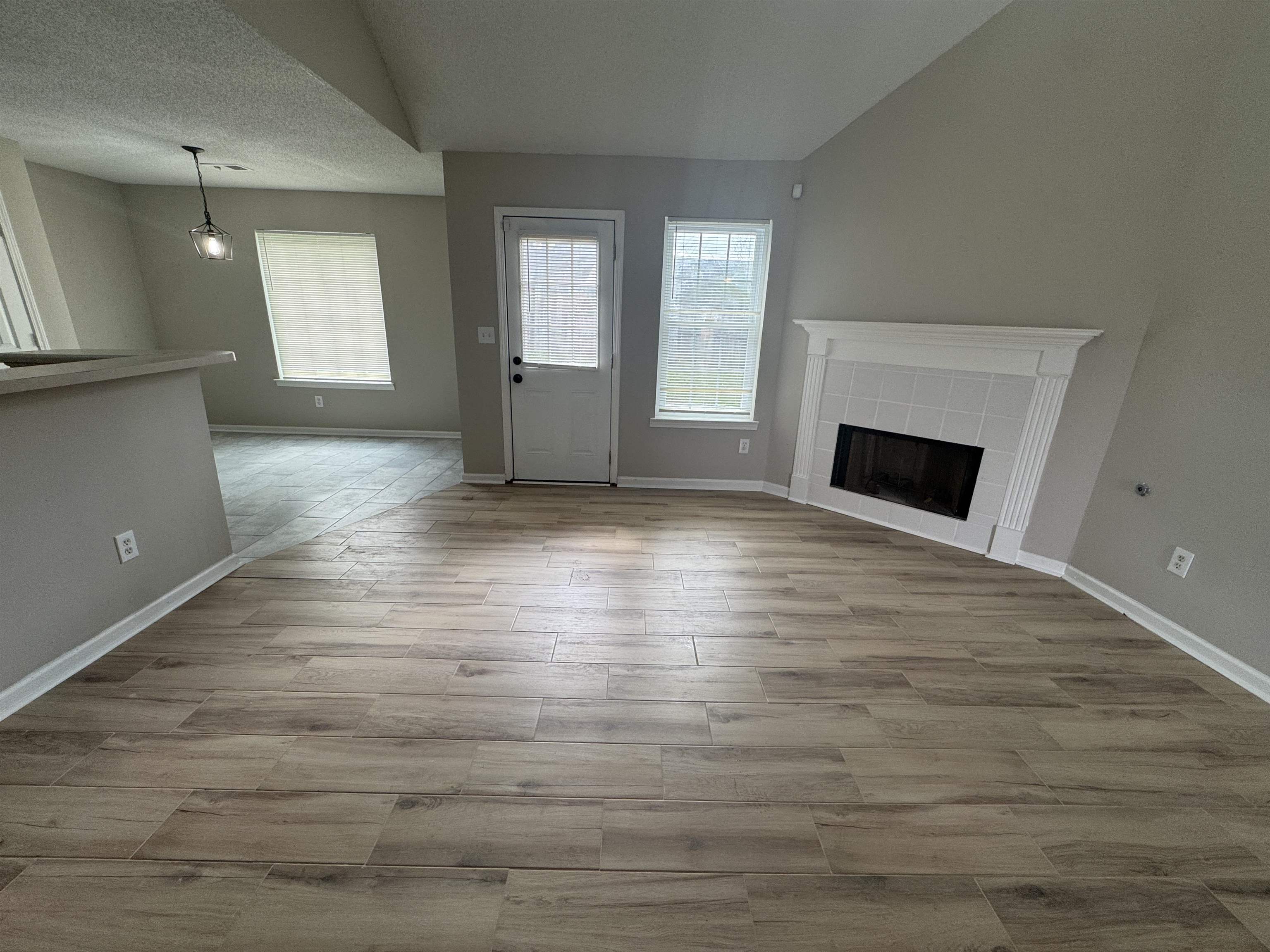 5457 Sundale Way South Memphis, TN 38135 - Photo 5 of 23 Unfurnished living room with a fireplace, light wood-style floors, and a textured ceiling