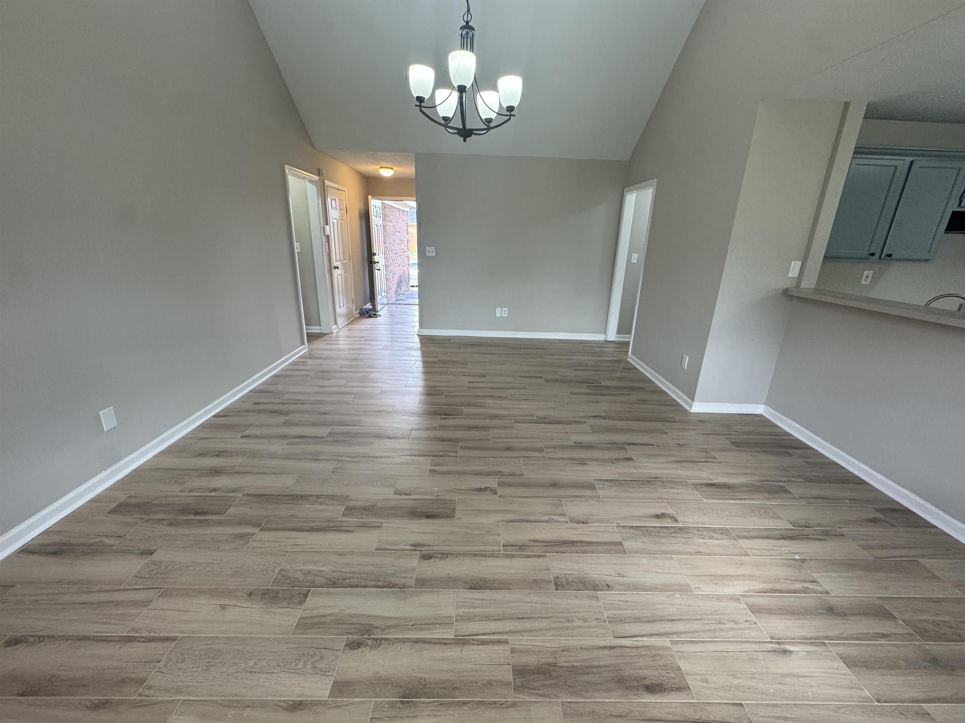5457 Sundale Way South Memphis, TN 38135 - Photo 7 of 23 Unfurnished dining area with suspended lighting, vaulted ceiling, and light wood finished floors