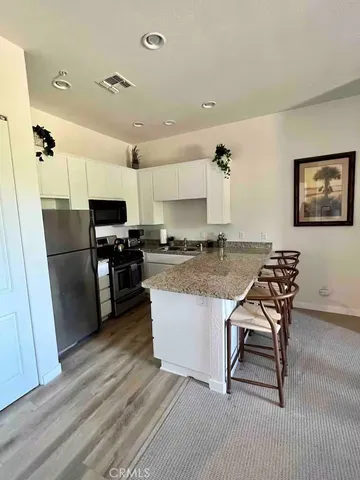 a bedroom with two beds and potted plant on the dresser