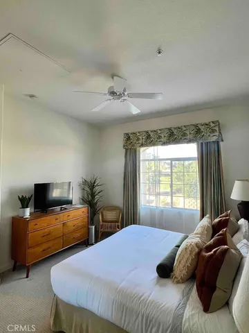 a bedroom with a bed and a television