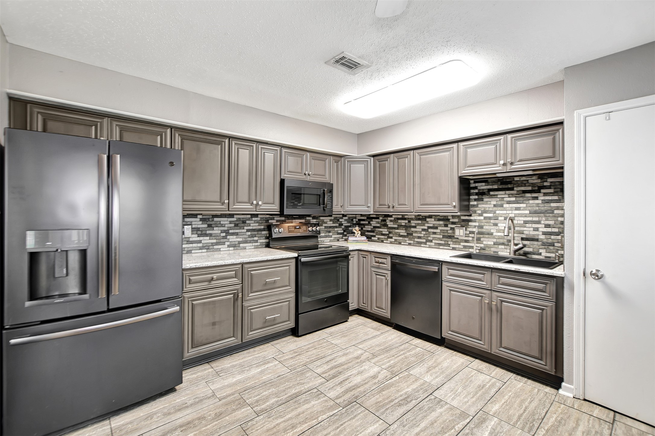 8 Arlington Street Conroe, TX 77301 - Photo 19 of 43 a kitchen with a refrigerator sink and cabinets