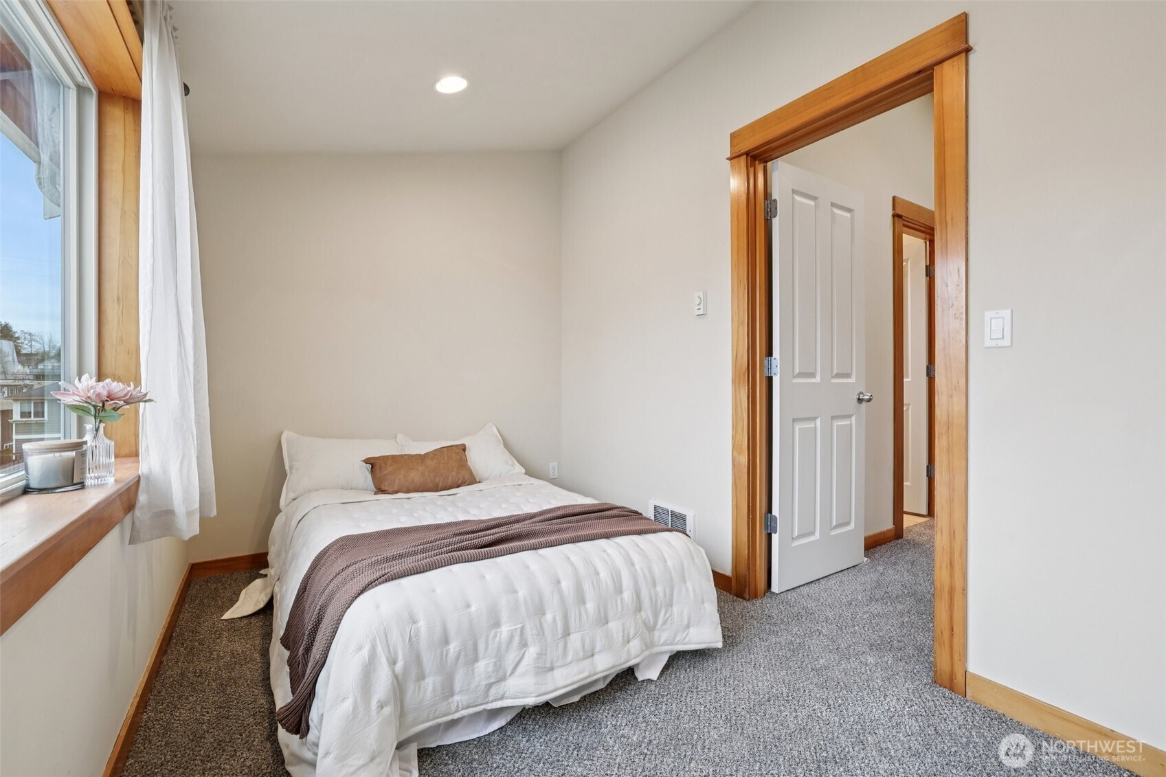 9047 17th Avenue Southwest, Unit A Seattle, WA 98106 - Photo 25 of 29 a bed sitting in a bedroom next to a window