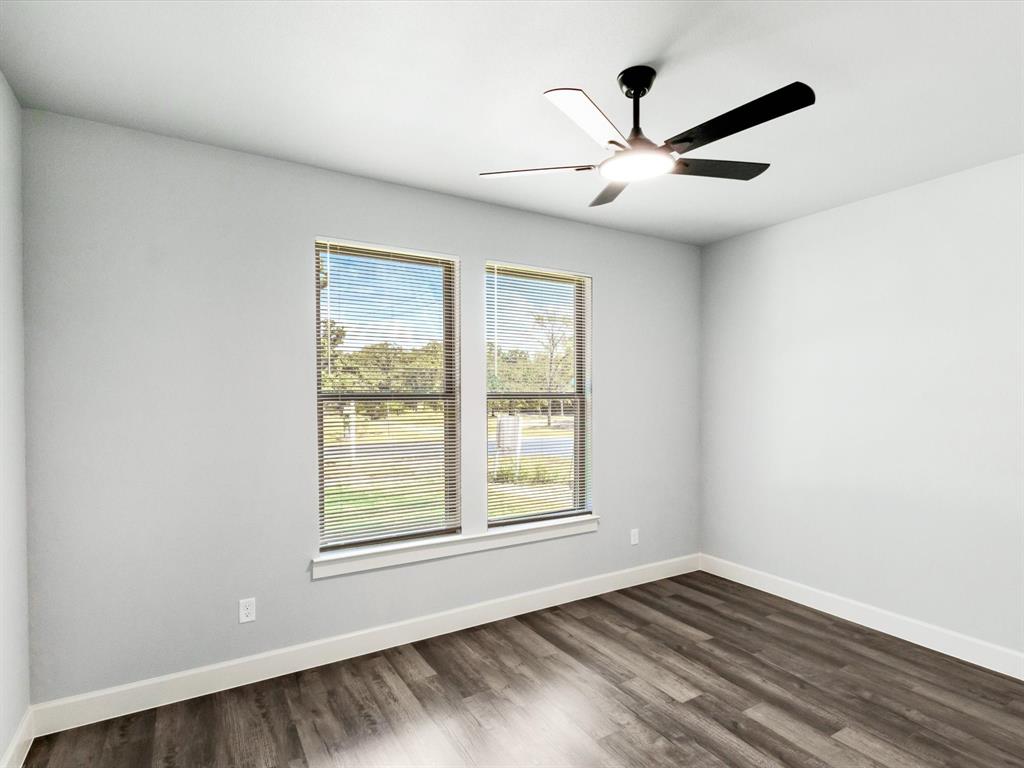 4705 Point La Vista Road Malakoff, TX 75148 - Photo 11 of 40 Dual windows with horizontal blinds, wood-finish flooring, and a ceiling fan with integrated lighting