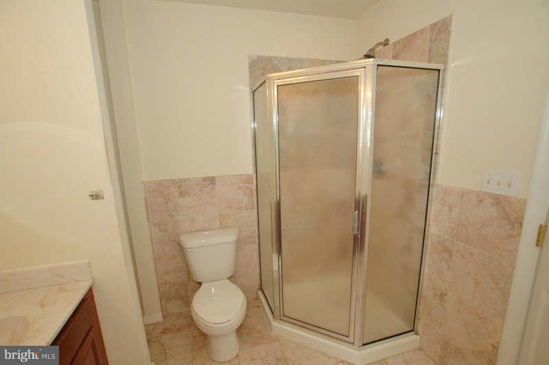 3641 Clifmar Road Baltimore, MD 21244 - Photo 16 of 27 a bathroom with a granite countertop toilet and a shower