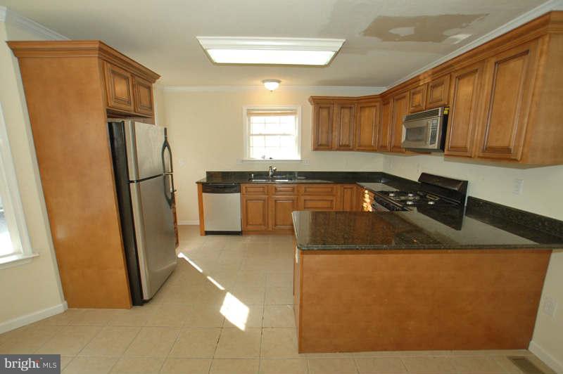 3641 Clifmar Road Baltimore, MD 21244 - Photo 4 of 27 a kitchen with a sink refrigerator and microwave
